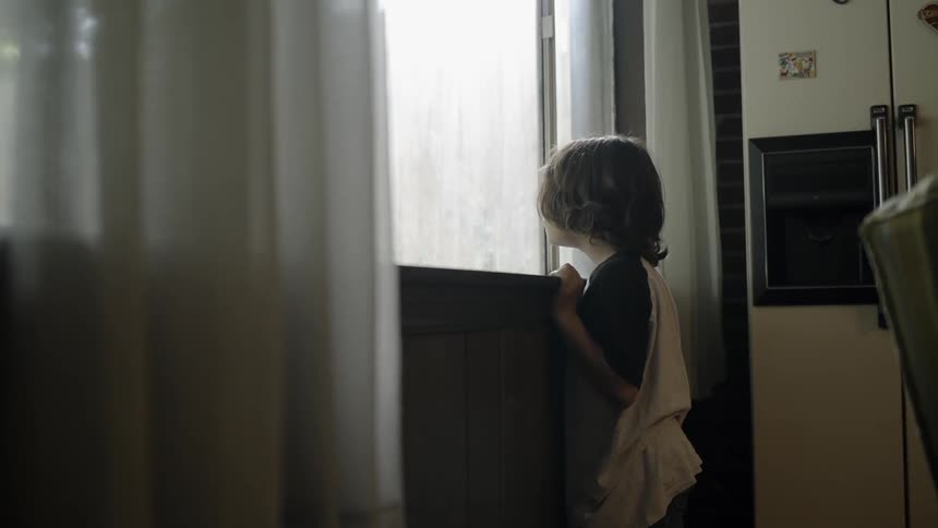 Child runs up to a window and looks out
