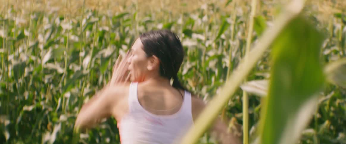 A woman running through a corn field