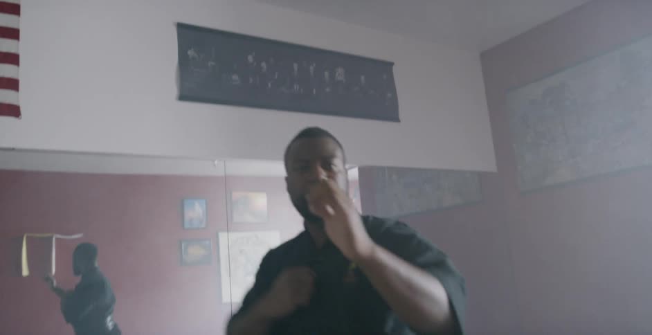 A man practicing a martial arts spin inside of a studio