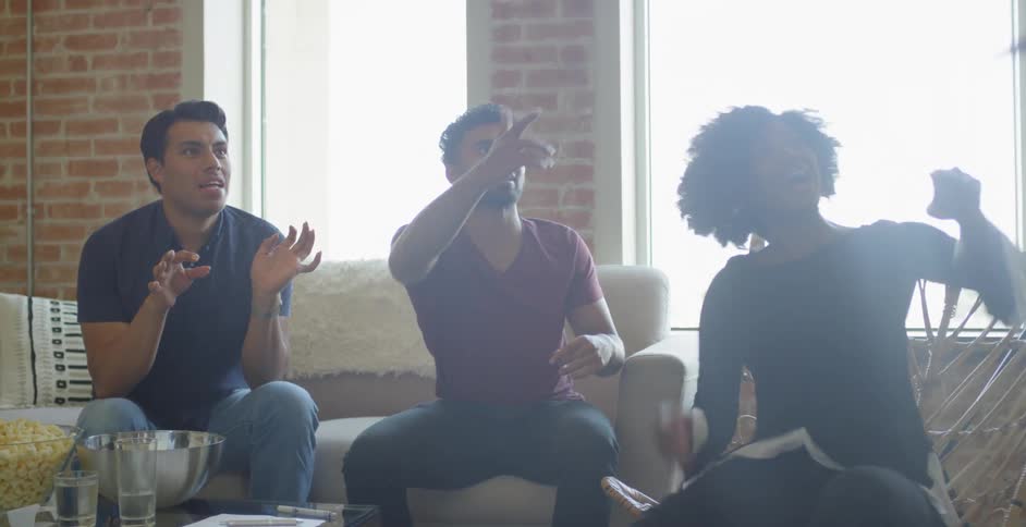 People are sitting on a couch talking together