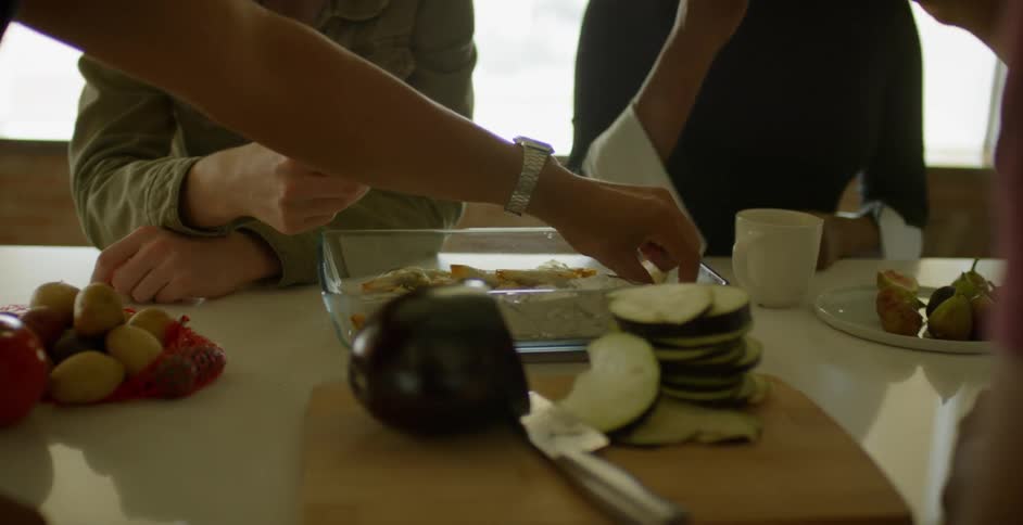 Friends eat snacks while gathered around a table