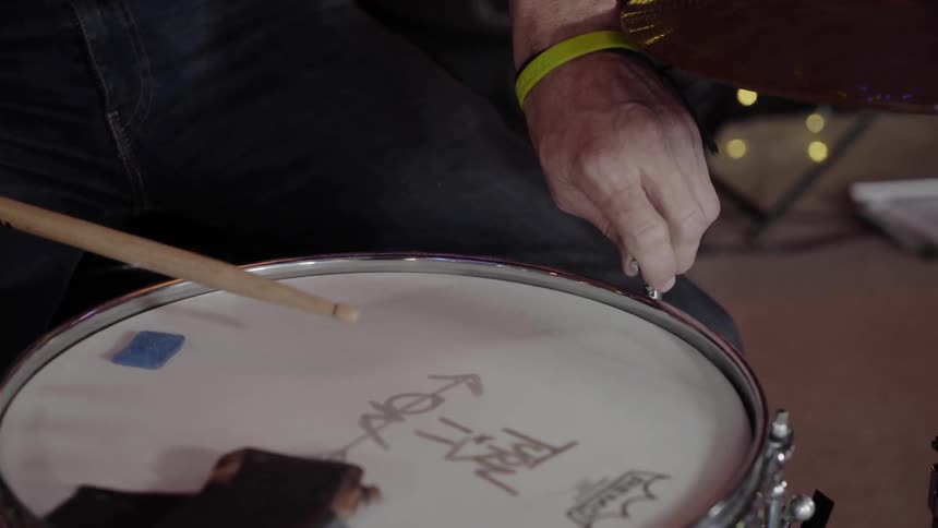 A person tightening a drum