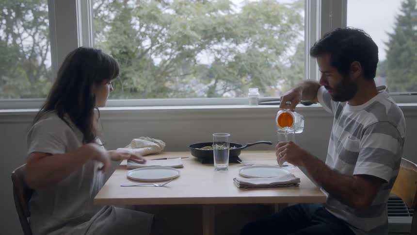 Woman and man sit at a small table to have lunch