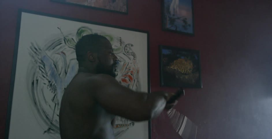 Man waves nunchucks around near paintings