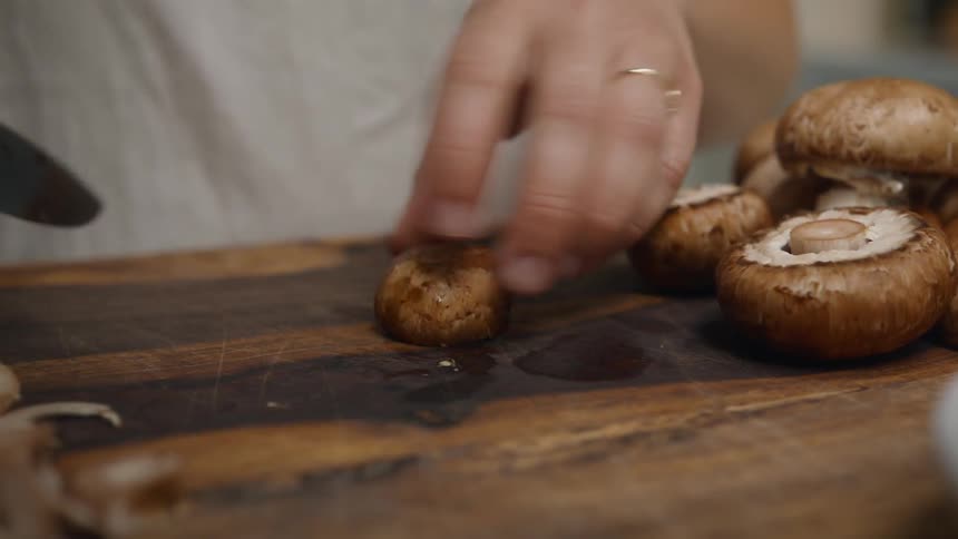 Cook chopping mushrooms on a butcher block