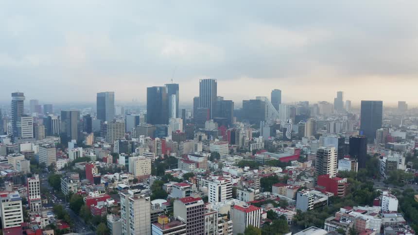 Clouds float above city skyscrapers at sunset