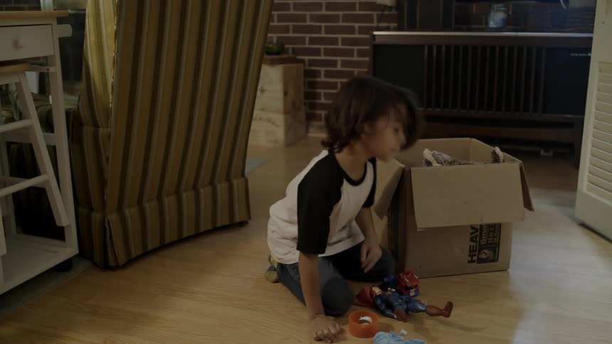 Child takes items out of moving box