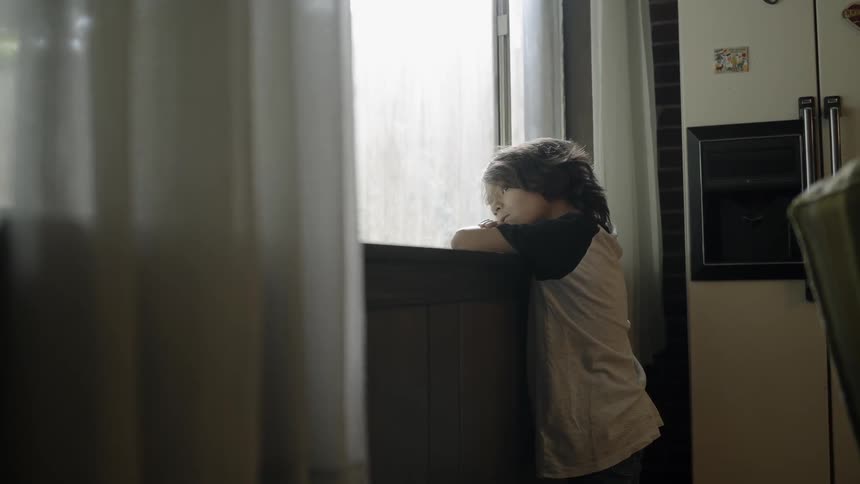 A boy walking up to a window