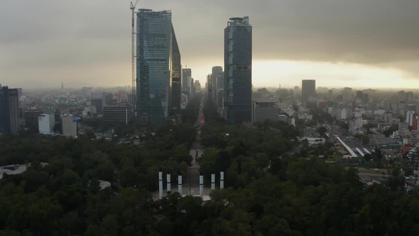 Clouds float above city skyscrapers at sunset