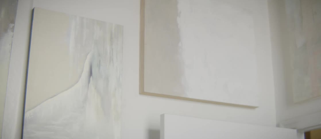 Paintings are displayed on the white wall