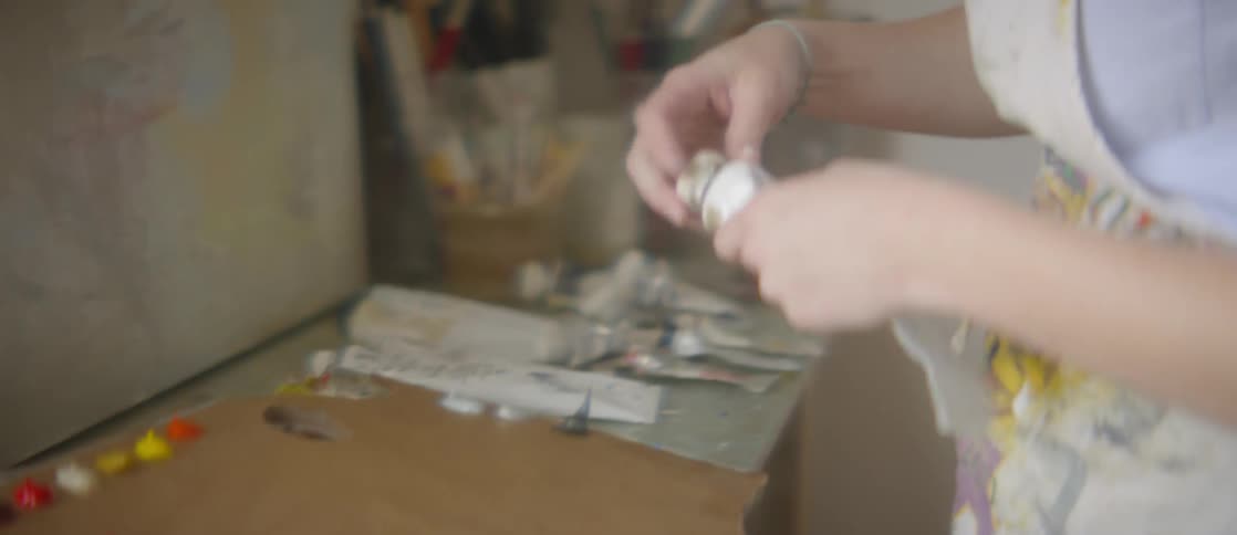 Woman closes paint squeeze bottle