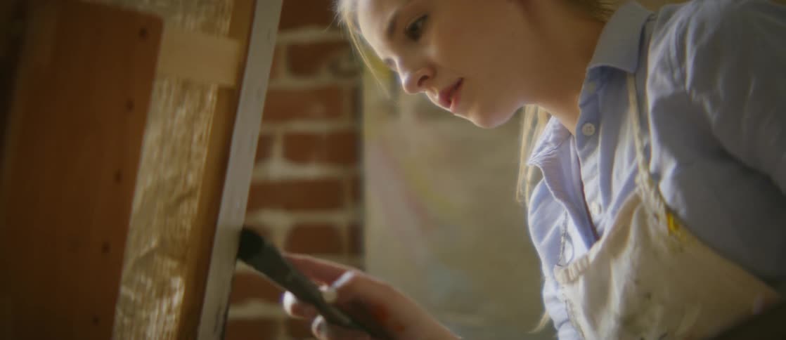 A woman paints on a canvas