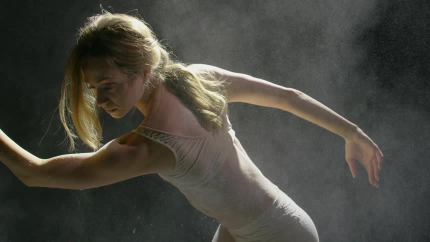 A woman dances as powder is thrown on her