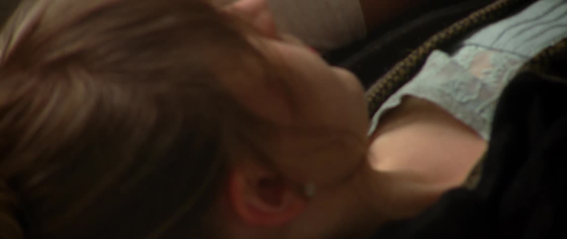 Close up of a man and woman's hand intertwined, while they lay together
