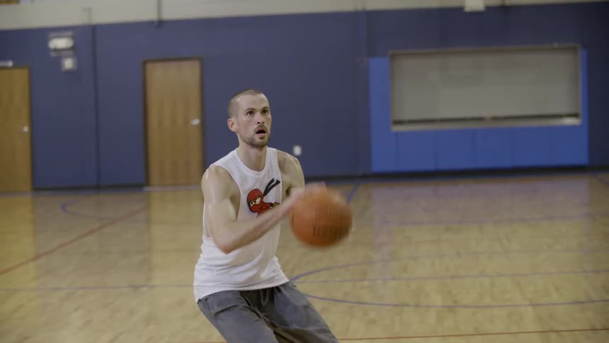 Man plays basketball inside a gym