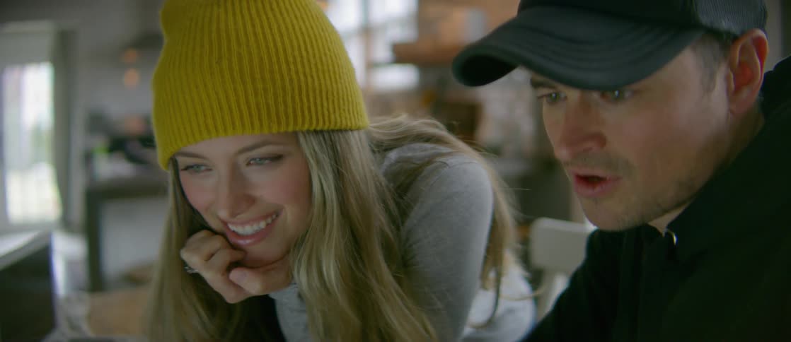 A woman and man are smiling and talking