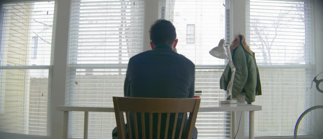 Man standing up from a typewriter sitting on a desk