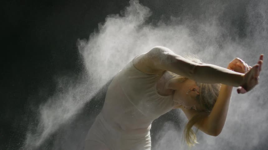 A woman dances as powder is thrown on her