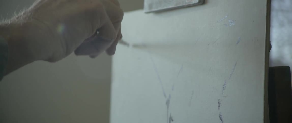 An artist brushes paint onto a canvas