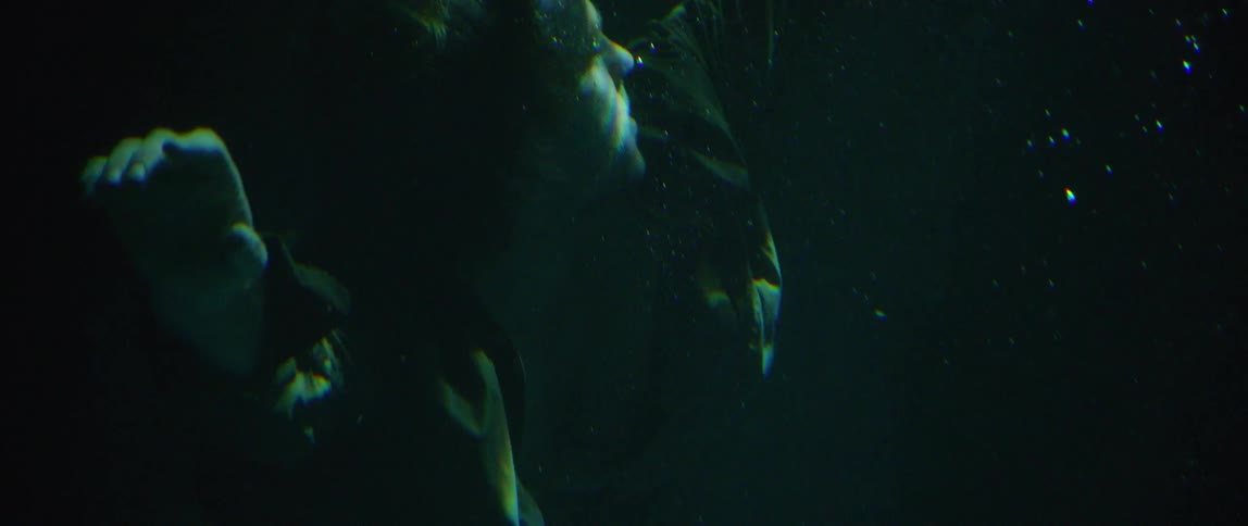 A man floating underwater and looking around