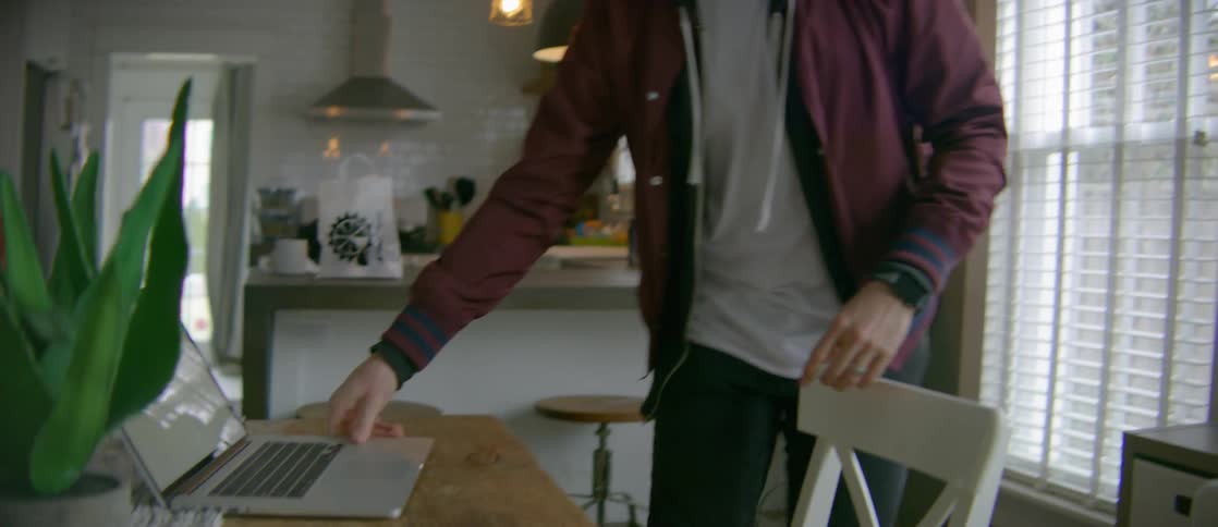 A man puts a laptop on a dining table