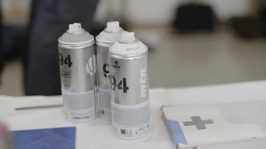 Cans of spray paint sit on a table
