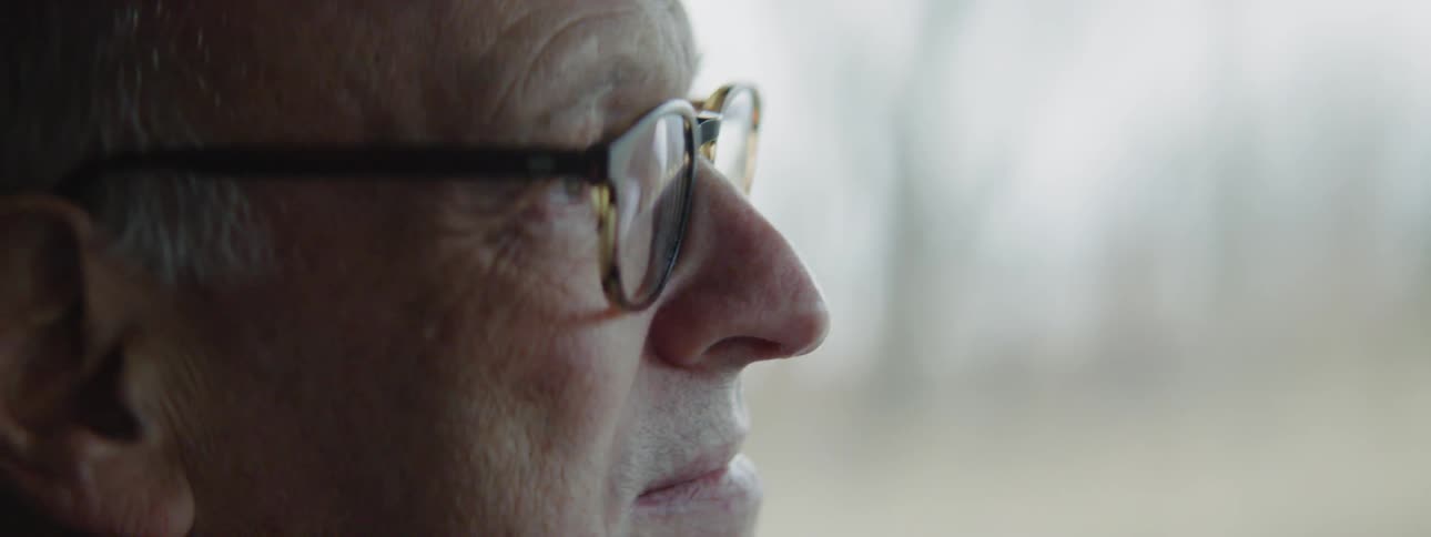 A man wearing glasses is driving