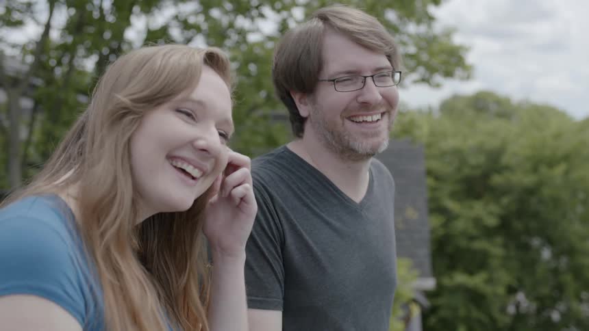A man and woman are smiling outside