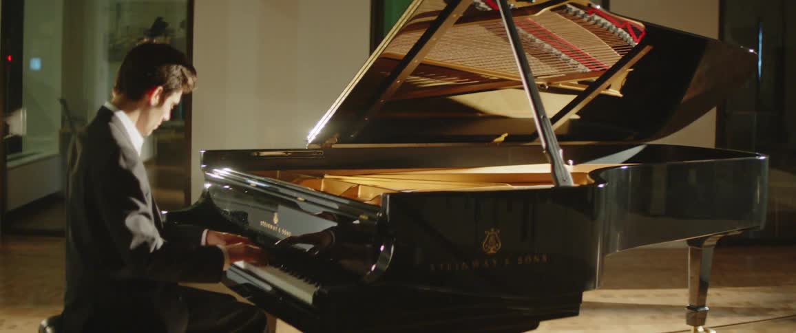 Man in suit plays piano