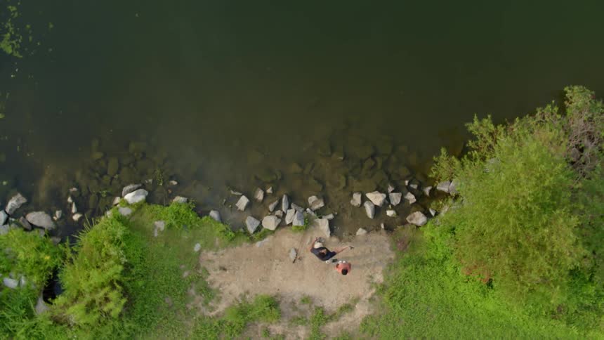 A father and son fish from a lakeshore