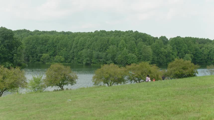A family flying a kite next to a river