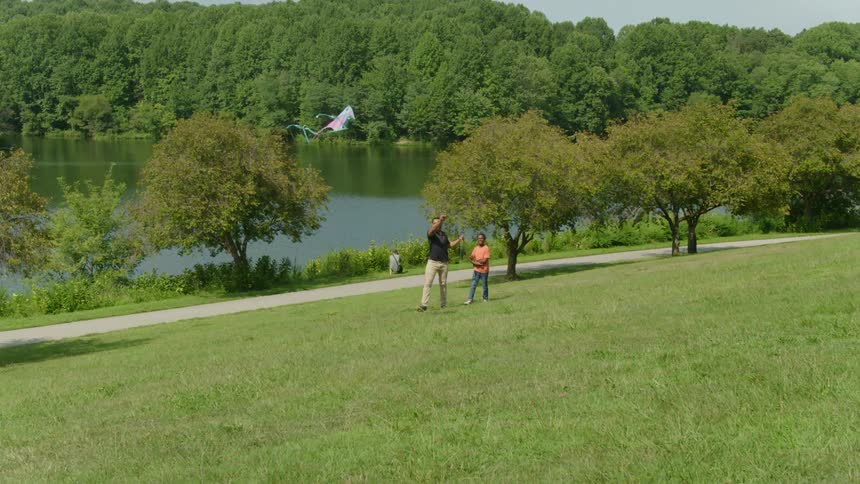 A man and child fly a kite together