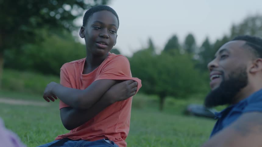 Child reaches out and touches man and speaks in public garden