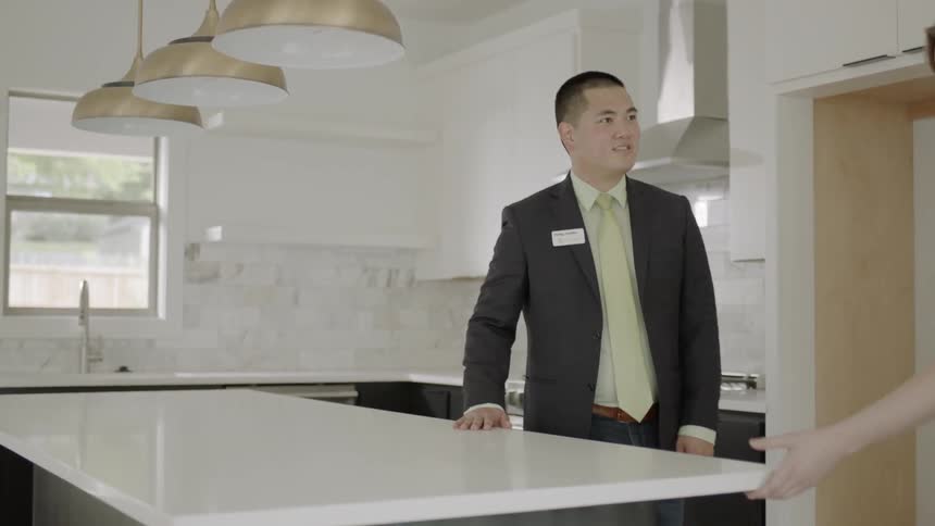 A real estate agent shows a house to a young couple