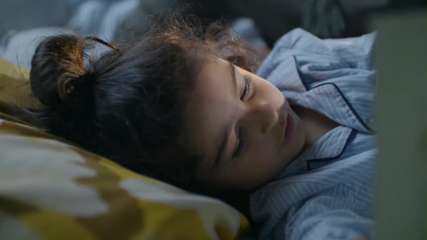 A child is reading in bed