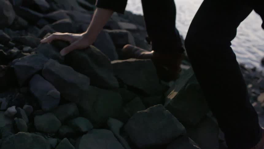 A man climbing up a pile of rocks