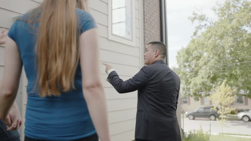 A man shows a couple a home for sale