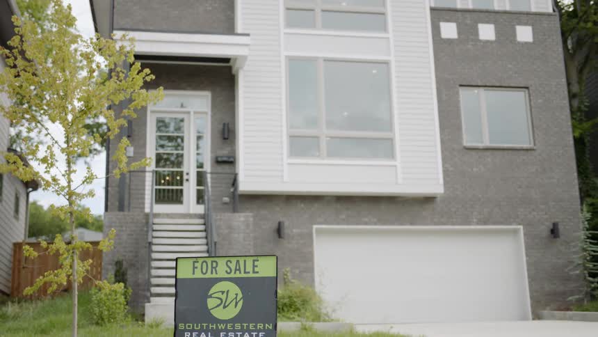 The outside view of a house with a for sale sign