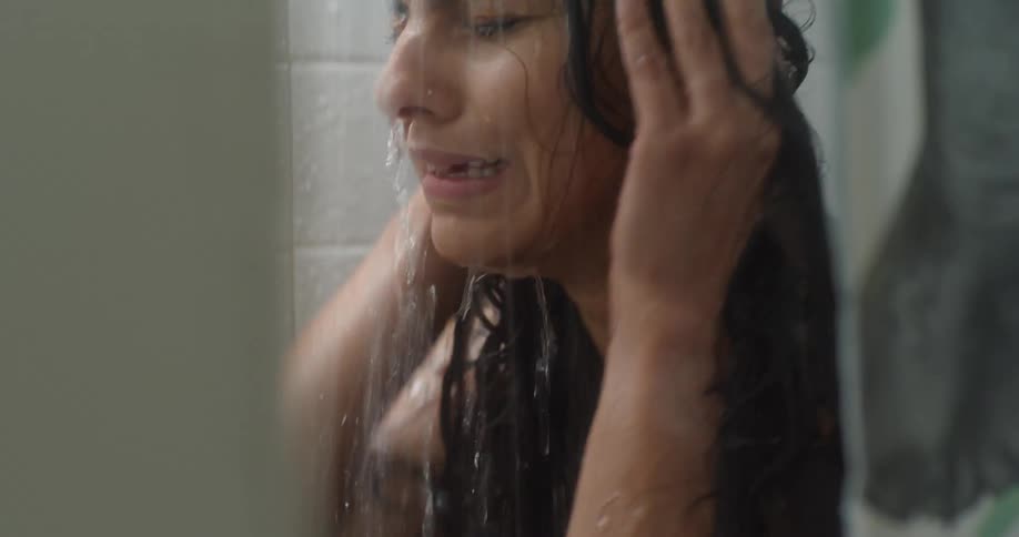 A woman cries while taking a shower