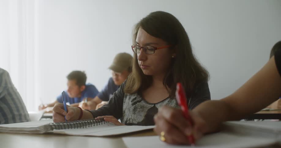 People are in a classroom writing notes