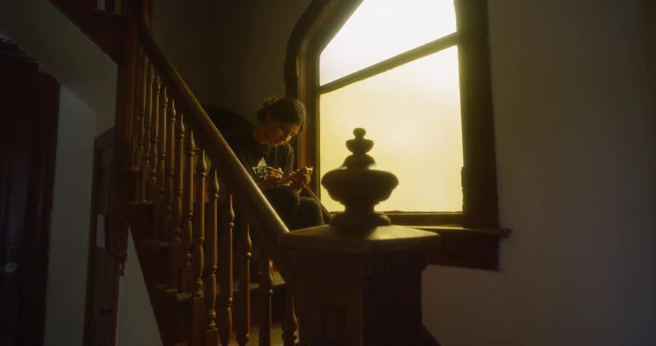 A person is on their phone sitting on stairs