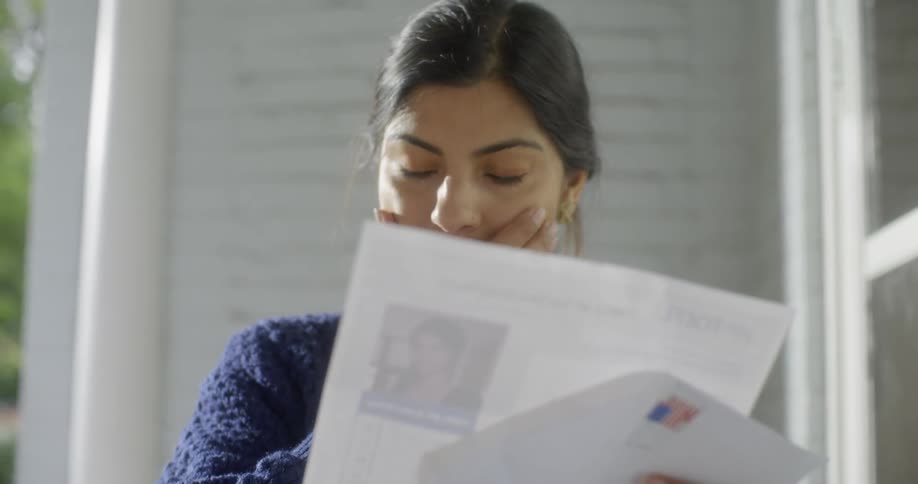 A woman is looking through some papers outside