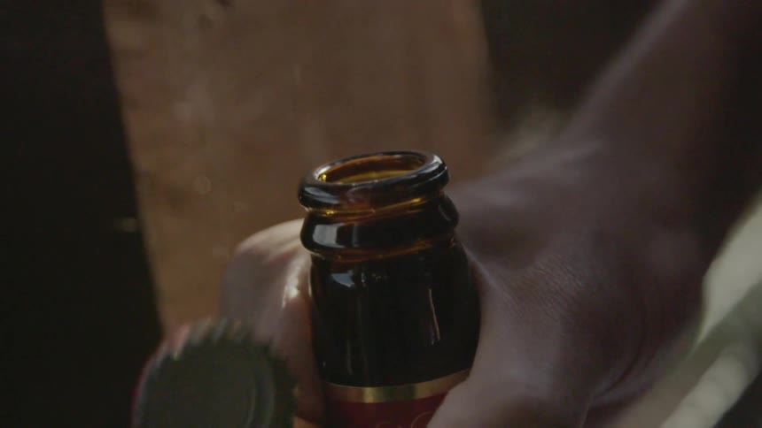 A bottle opener removing a cap