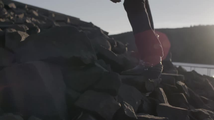 A person climbing up a rocky hill