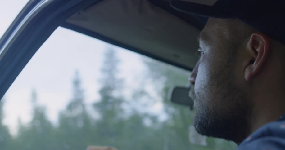 A man driving a car in a forest