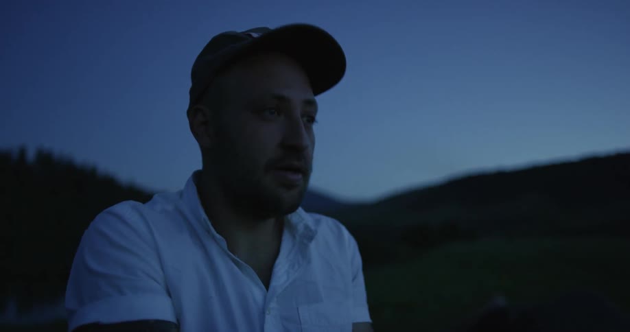 A photographer takes a picture outside at dusk
