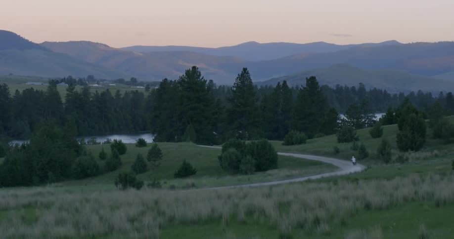 A person is riding a bike outdoors at dusk