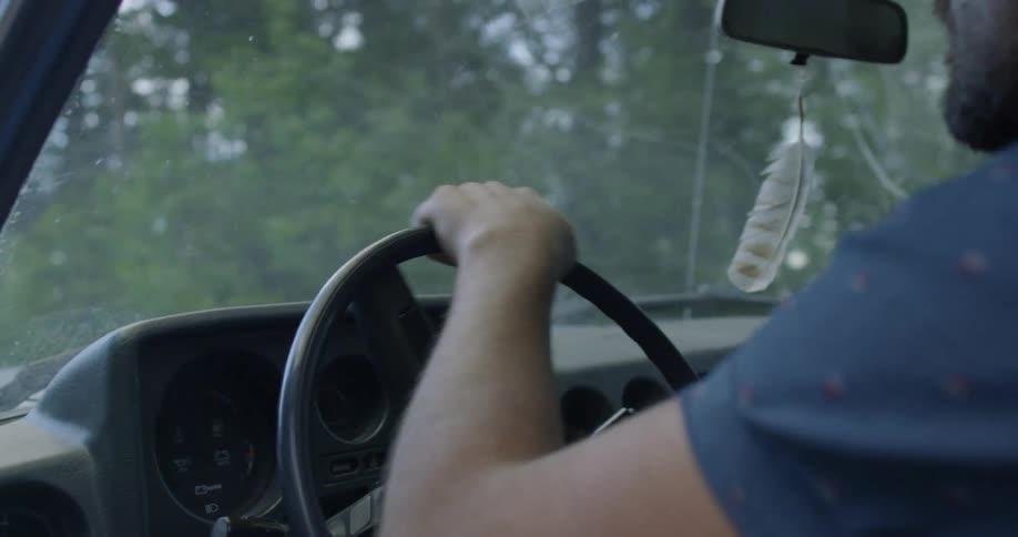 A man drives in a forest