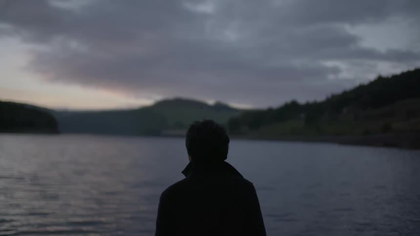 A man stares out into the water