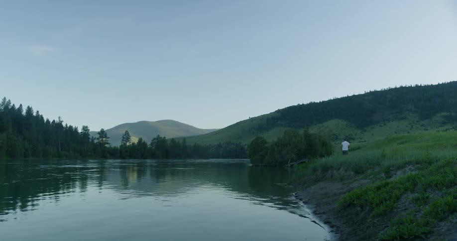 A man is outside by a lake